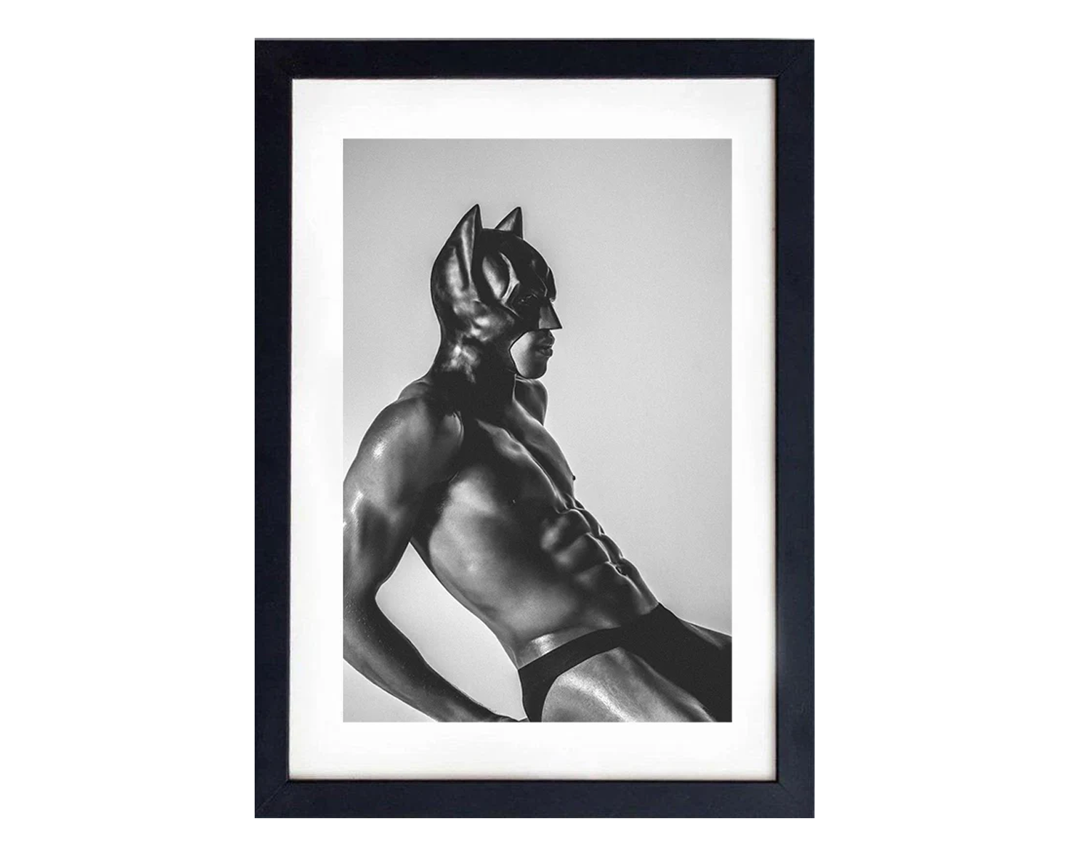 Framed black and white photo of a muscular figure wearing a mask and briefs.