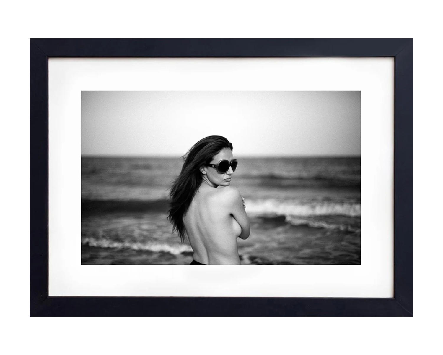 Framed black and white photograph of a person on a beach.