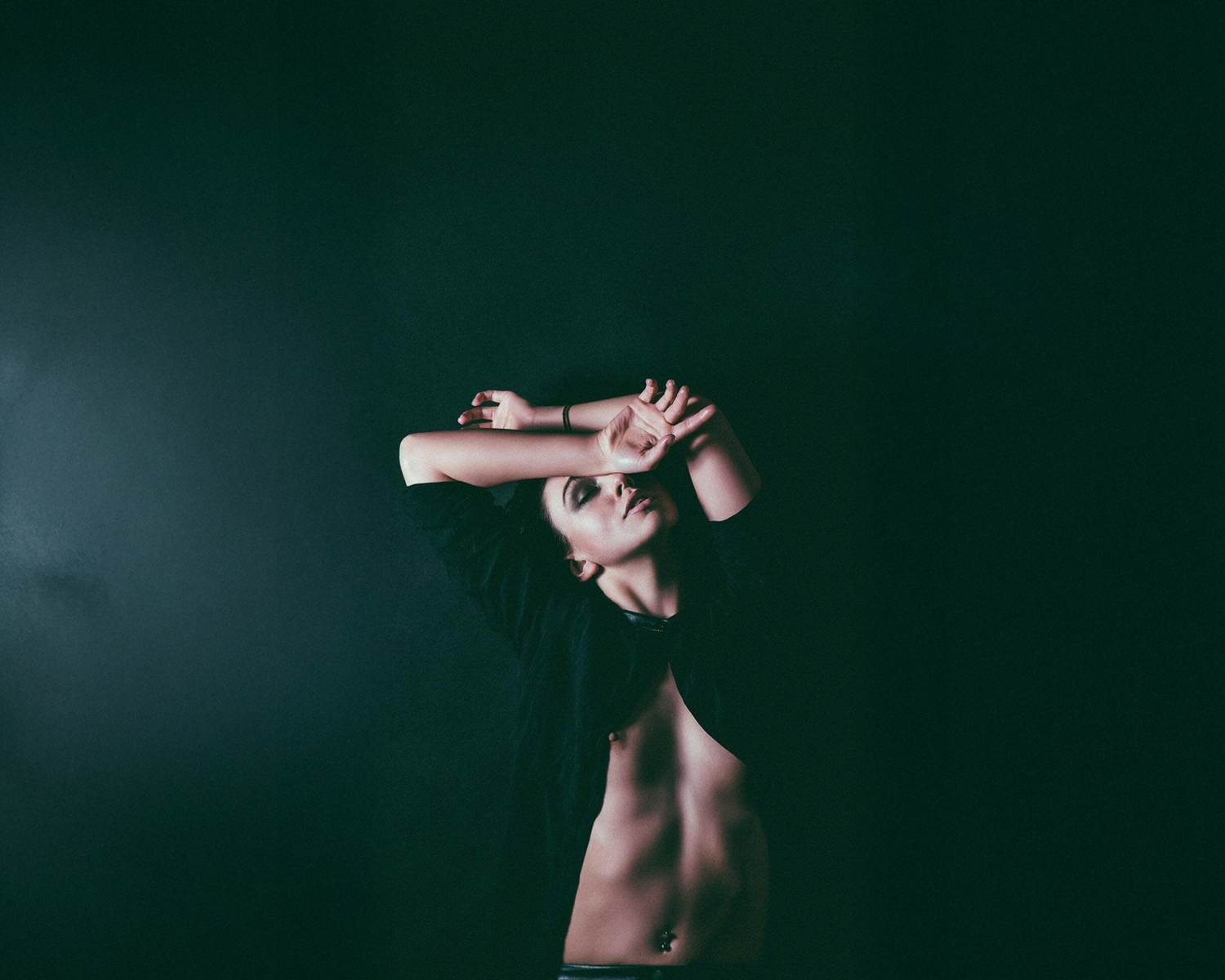 Girl wearing a black long-sleeve shirt against a dark background