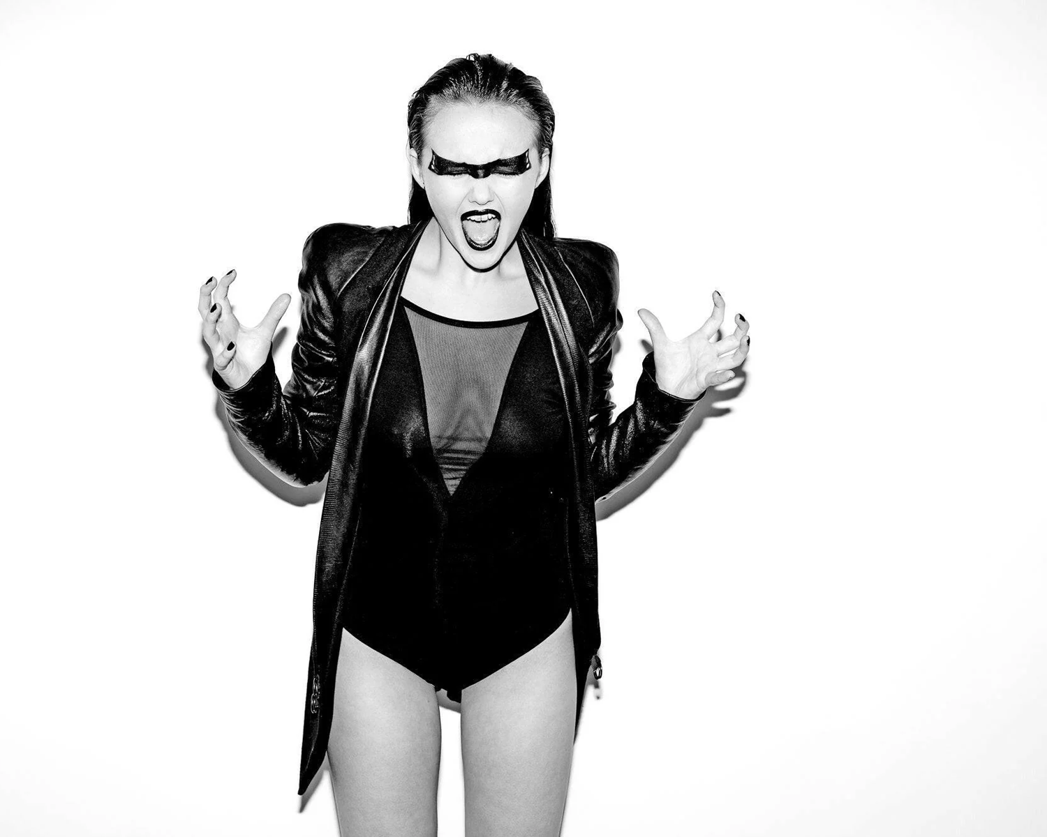Girl wearing a black leather jacket and bodysuit on a white background