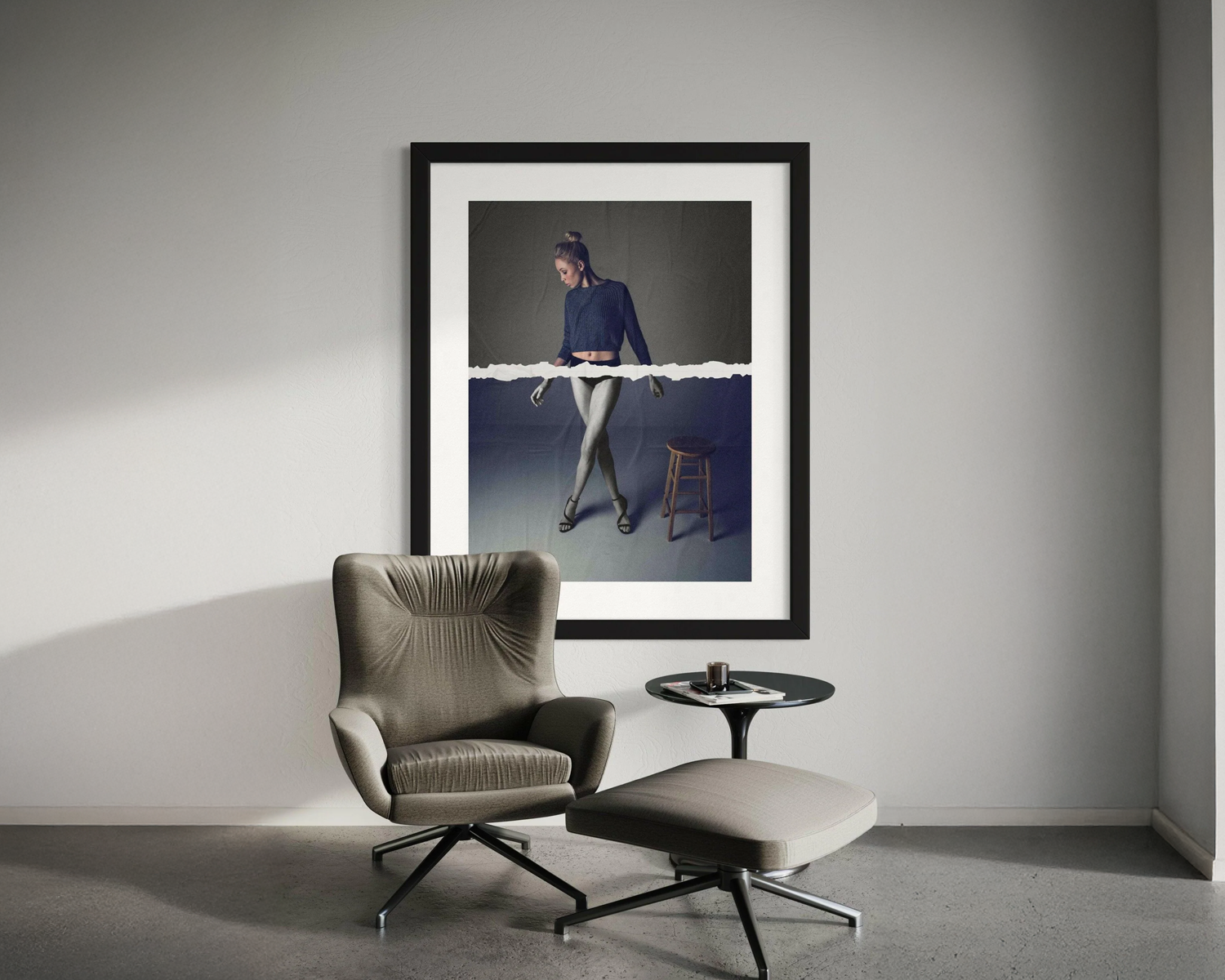 Framed artwork on a wall above a modern chair and ottoman.