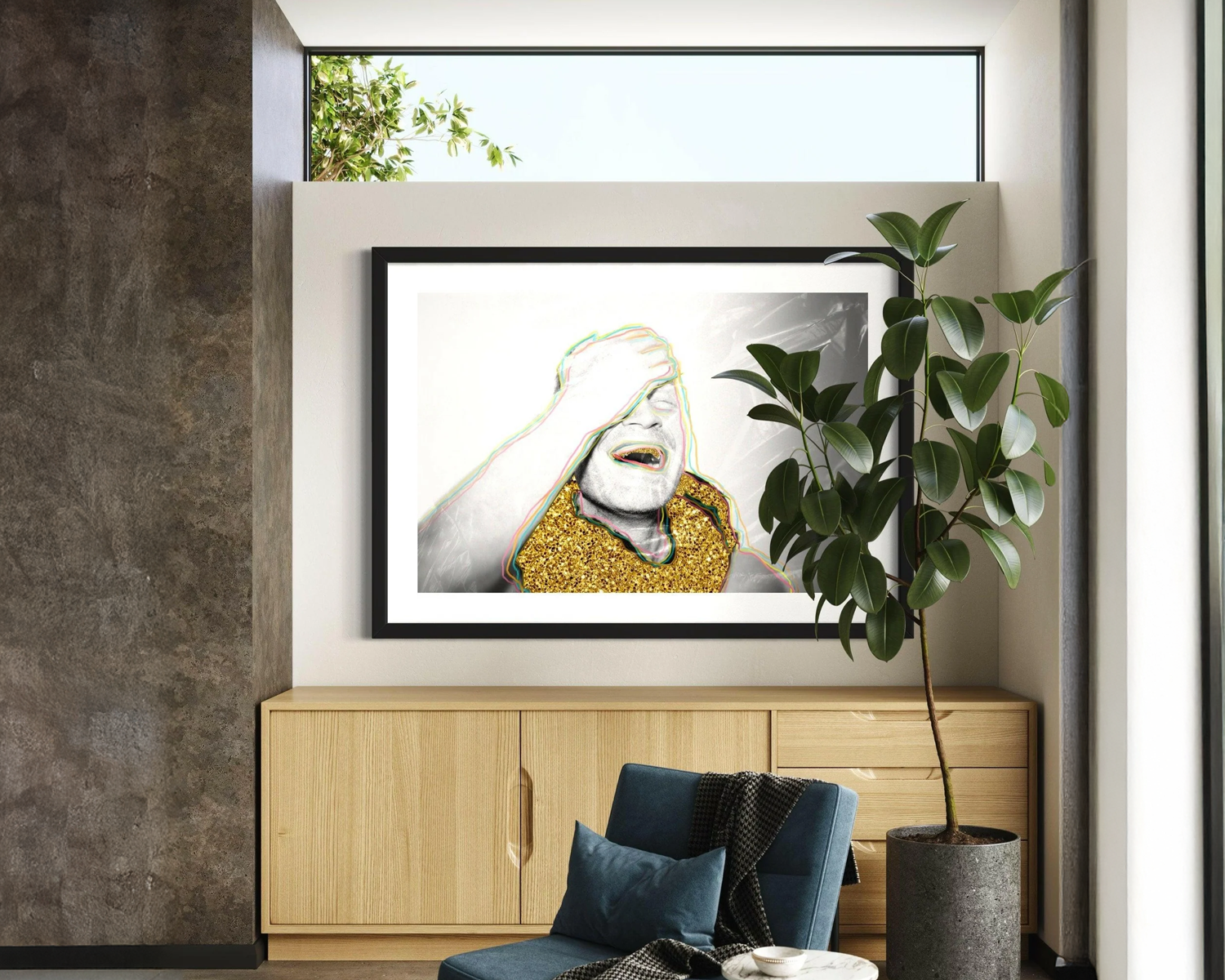 Framed artwork on a wall above a wooden cabinet with a plant and chair in the foreground.