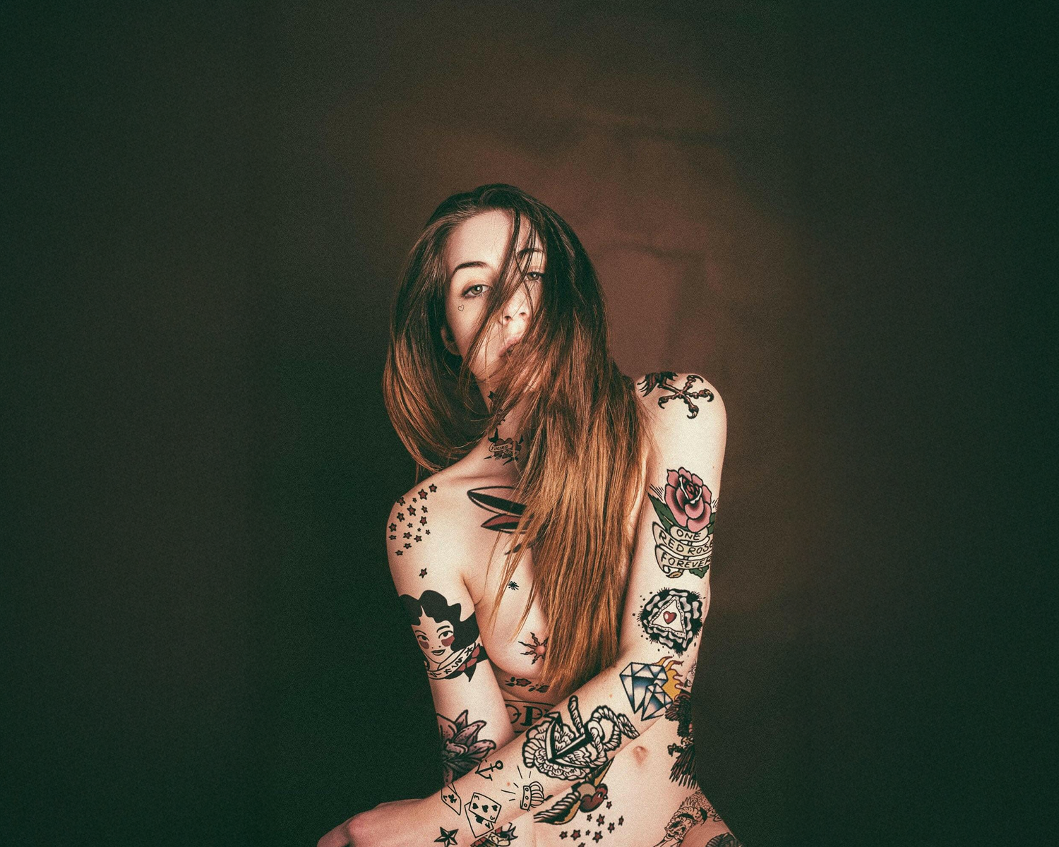 Woman with tattoos on a dark background