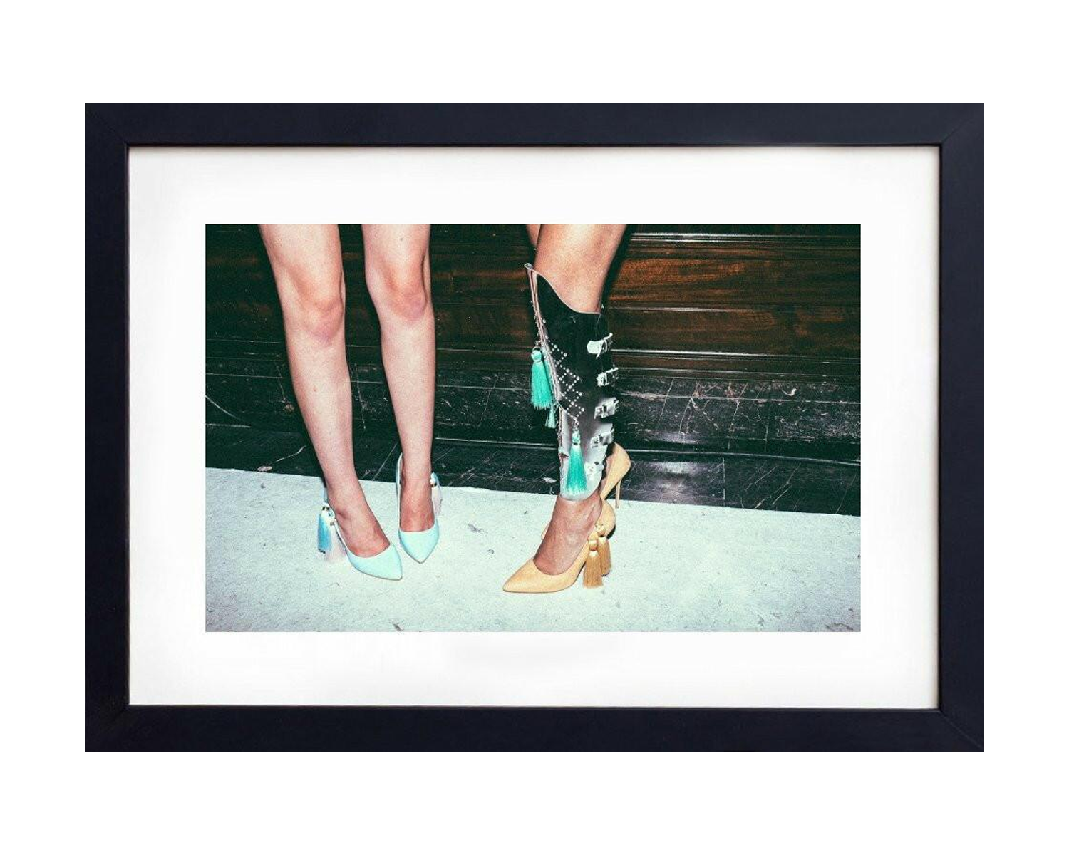 Framed picture of legs wearing high heels on a white background