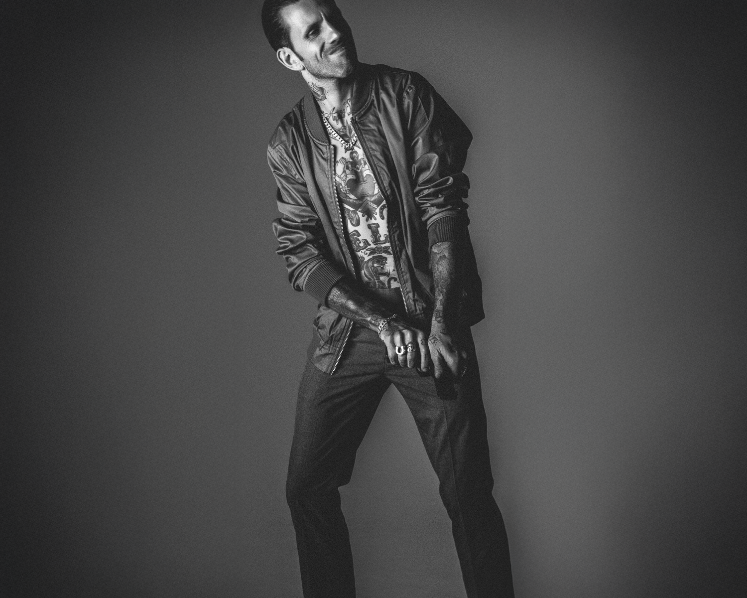 Man wearing a bomber jacket  against a gray background