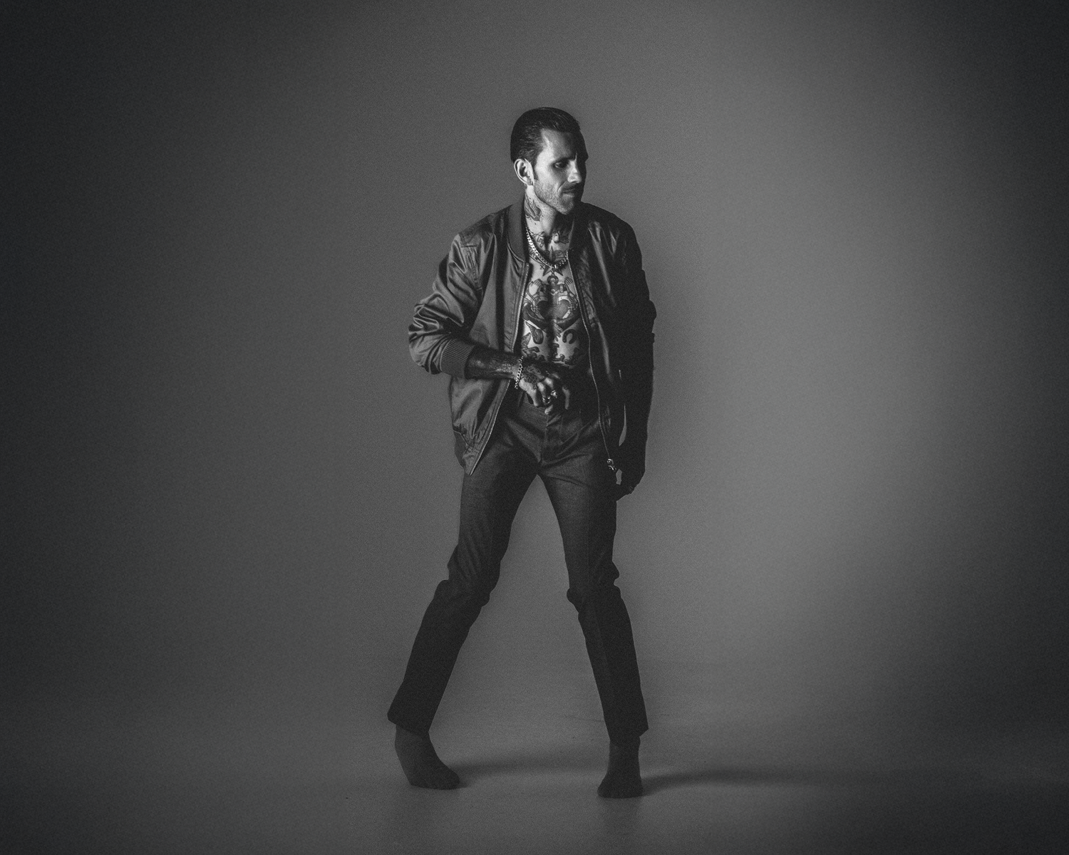 Man in a stylish outfit posing against a gray background