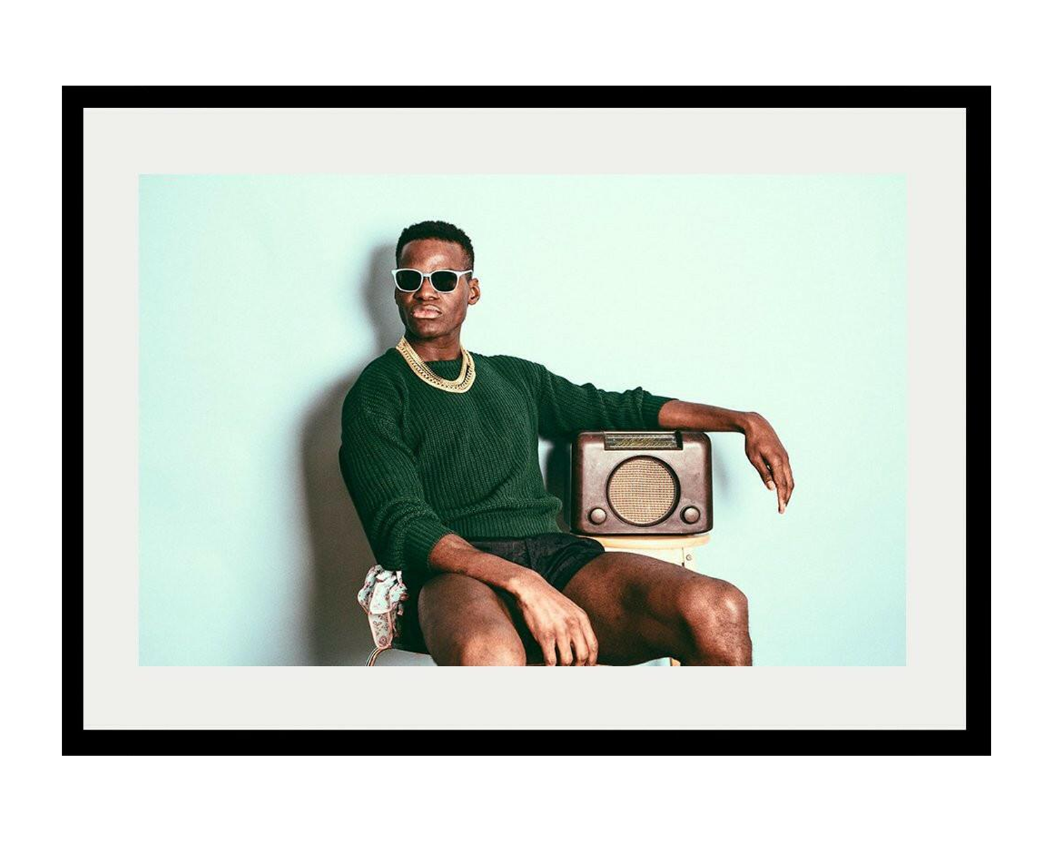 Man sitting with a vintage radio on a light blue background