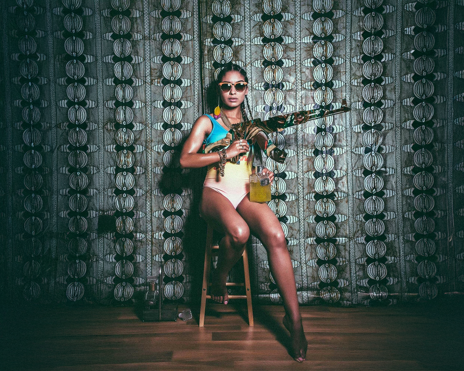 A woman in a swimsuit poses with a gun, showcasing a striking contrast against a sunny beach setting.
