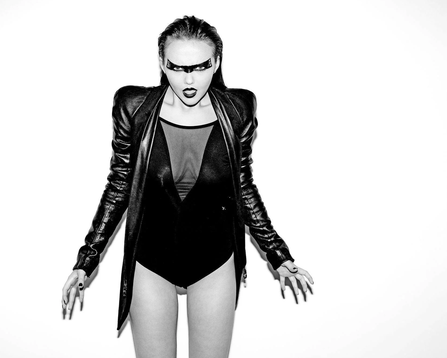 A woman in a black leather jacket paired with black underwear, showcasing a bold and edgy fashion statement.